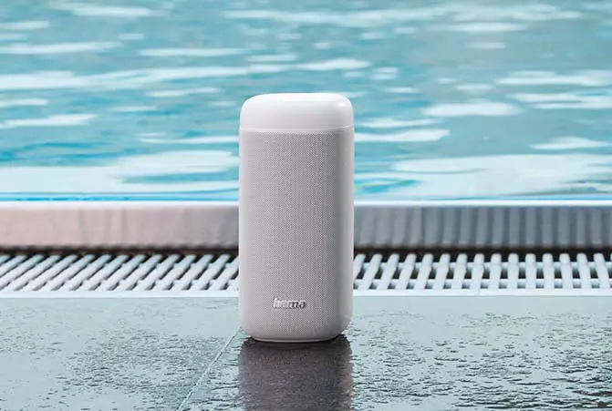 Bluetooth-Lautsprecher am Pool stehend.