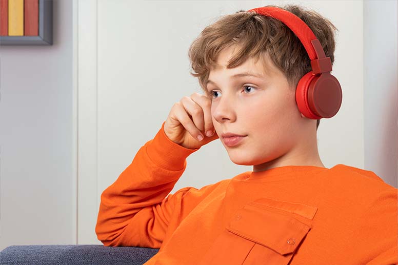 Jugendlicher hört Musik über Over-/On-Ear-Kopfhörer.