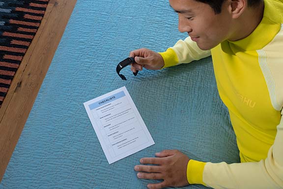 Person prüft Checkliste für Fitness-Tracker.