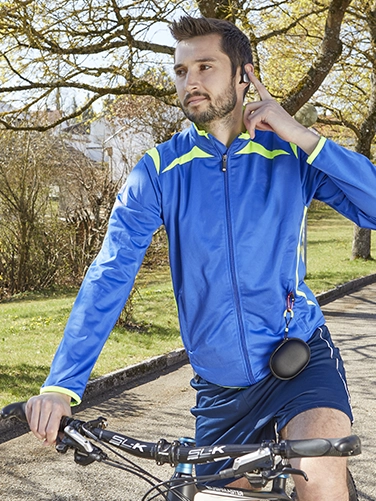 Junger, sportlicher Mann ist mit dem Rad unterwegs und hält an, um einen Anruf über den Hama Bluetooth®-Kopfhörer "Spirit Athletics" anzunehmen
