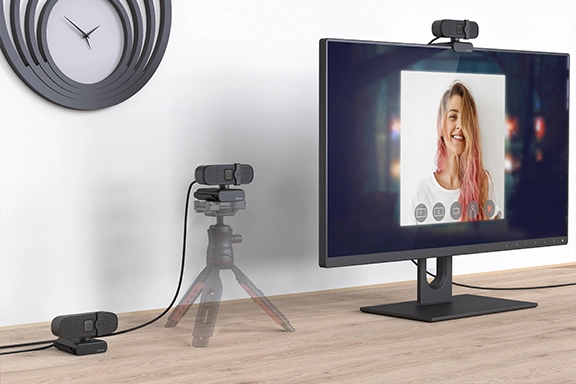 Ein eingerichteter Schreibtisch mit Bildschirm und drei Befestigungsmöglichkeiten für die Hama PC-Webcam "C-400", 1080p: stehend, auf einem Stativ oder an einem Bildschirm montiert