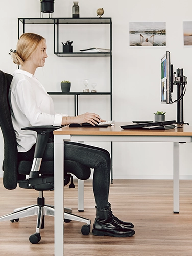 Junge Frau sitzt an einem ergonomisch eingerichteten Schreibtisch mit der Hama Mechanischen Office-Tastatur "MKC-650"