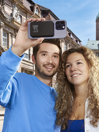 Mann und Frau machen in einer Stadt ein Selfie von sich.
