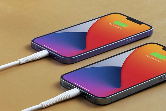 Zwei iPhones liegen auf einem Tisch und werden mit Ladekabel "Flexible" geladen